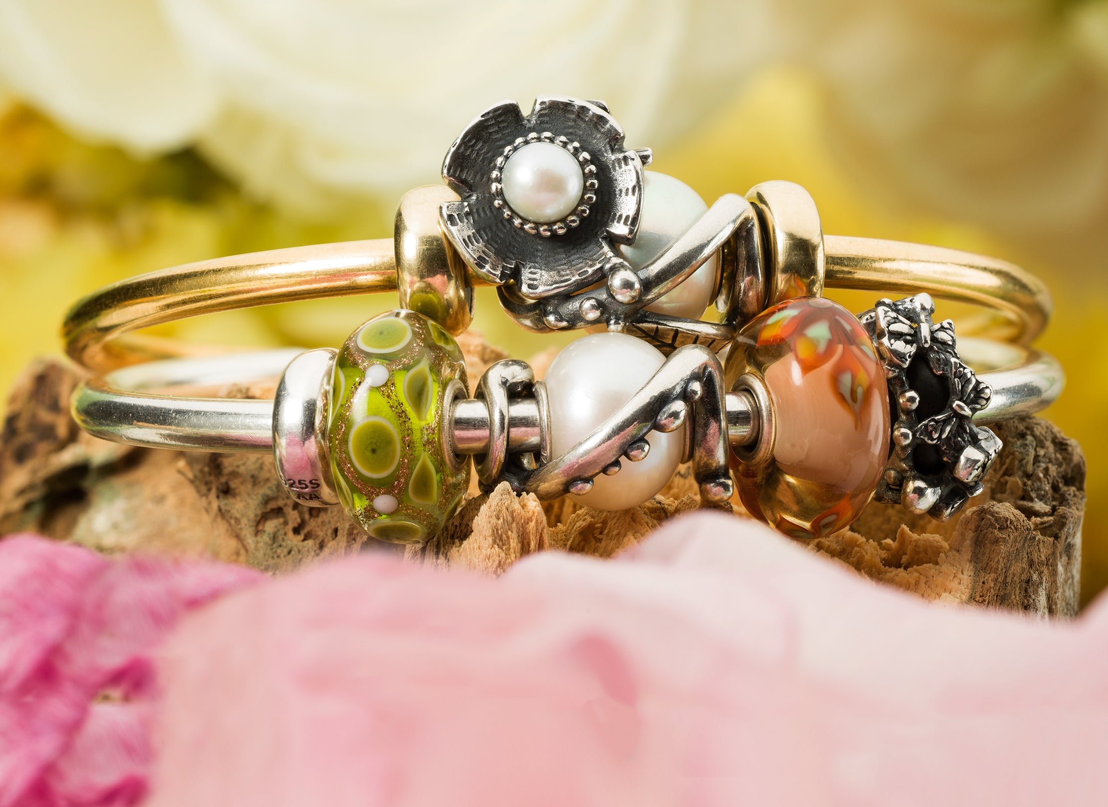Gold and silver Trollbeads bangles with framing beads pearls and flower beads